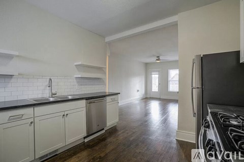 A kitchen with white cabinets and a black countertop.