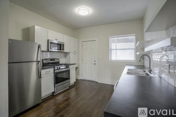 A kitchen with a refrigerator, stove, and sink.