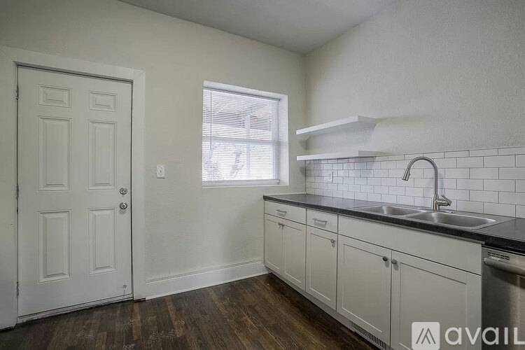 A kitchen with a white door and cabinets.