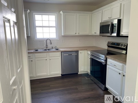 A kitchen with white cabinets and a stainless steel dishwasher.
