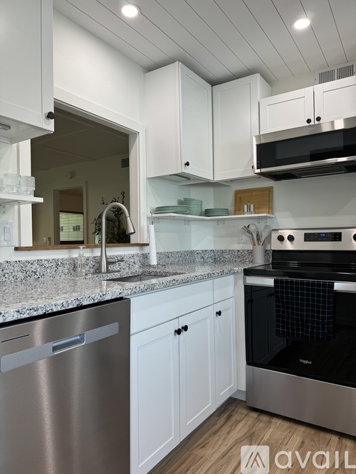 A modern kitchen with white cabinets and stainless steel appliances.