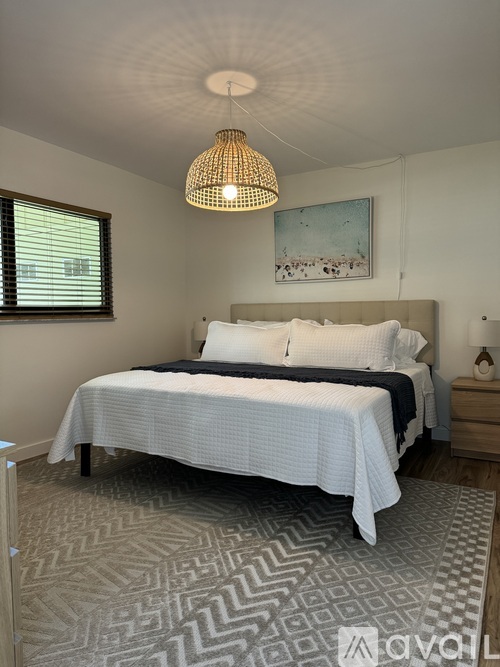 A bedroom with a large bed and a patterned rug.
