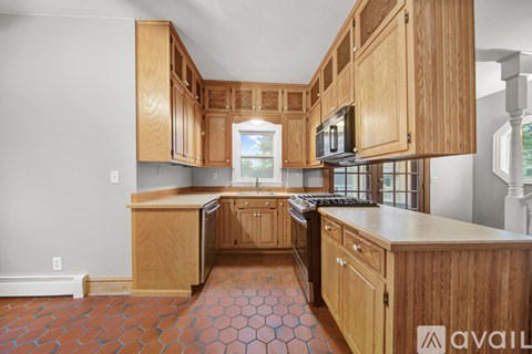 A kitchen with wooden cabinets and a tile floor.