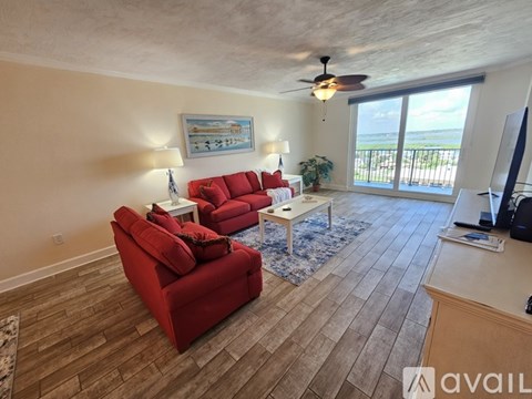 A living room with red couches and a wooden floor.