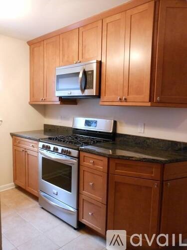 A kitchen with wooden cabinets and a black countertop.