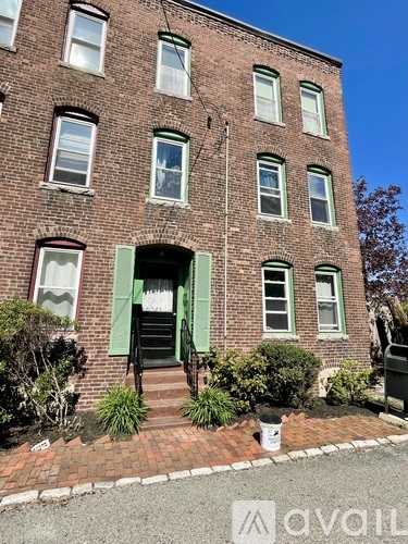A brick building with a green door and windows.