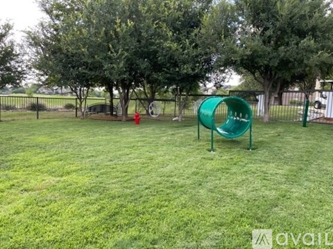 A playground with a green slide and a red fire hydrant.