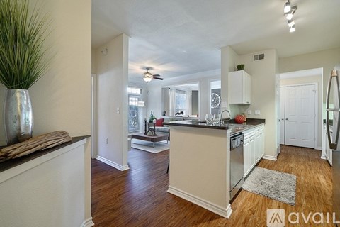 A kitchen with white cabinets and a wooden floor.