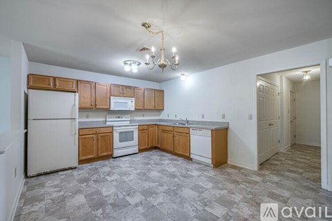 A kitchen with wooden cabinets and a white refrigerator.