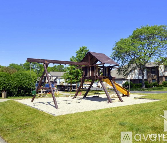 A playground with a wooden swing set and a yellow slide.