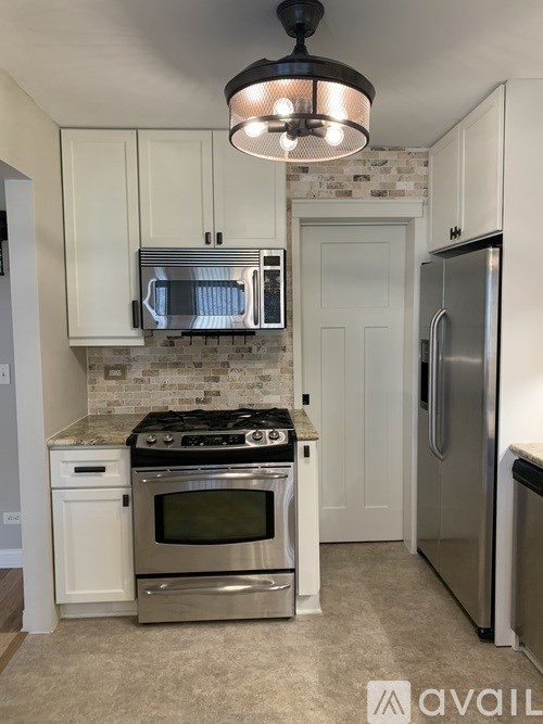 A kitchen with a stove top oven, microwave, and refrigerator.