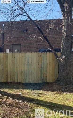 A wooden fence in front of a brick building.