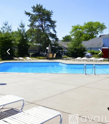 A pool surrounded by trees and a fence.