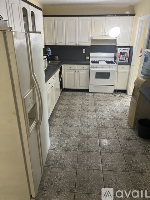 A kitchen with white appliances and cabinets.