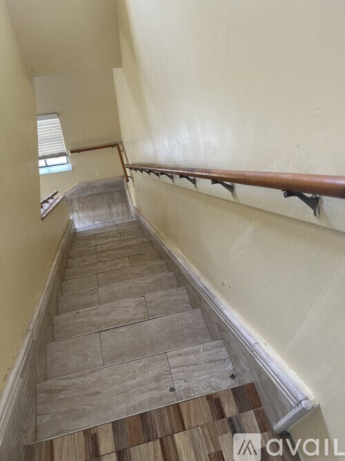 A staircase with wooden steps and a metal handrail.