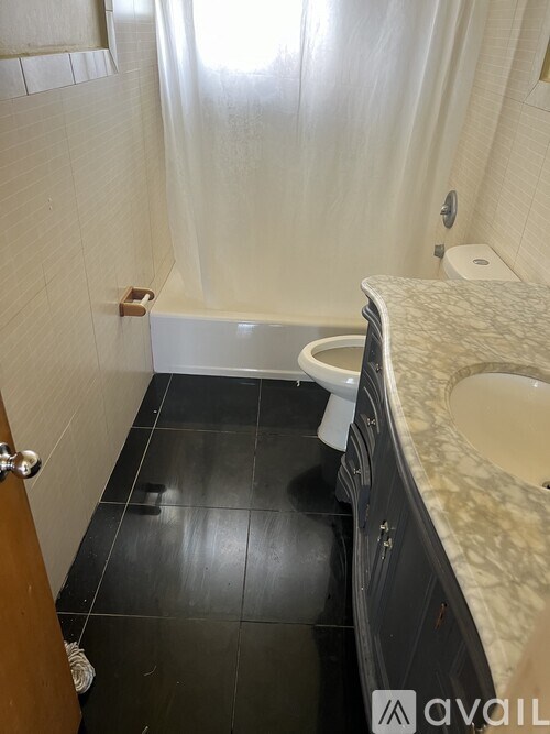 A bathroom with a toilet, sink, and bathtub.