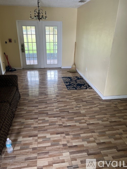 A room with a couch and a water bottle on the floor.