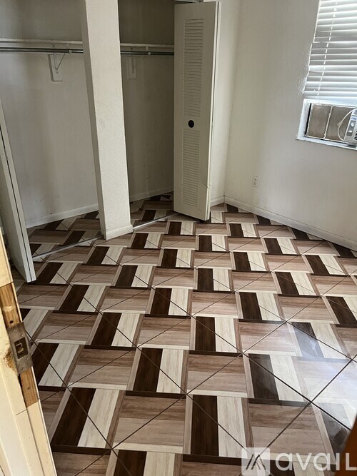 A room with a brown and white tiled floor and a white door.
