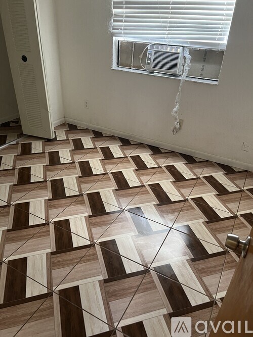 A room with a tiled floor and a window with blinds.