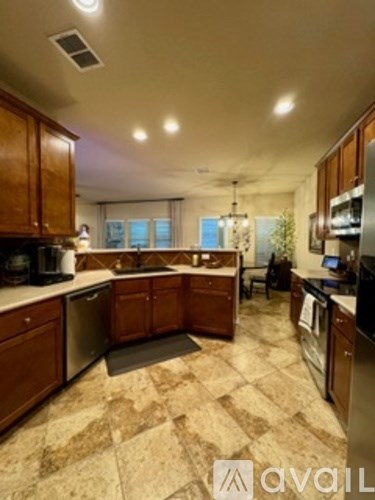 A kitchen with wooden cabinets and a tiled floor.