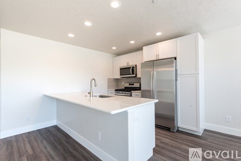 A kitchen with white cabinets and a white island with a sink.