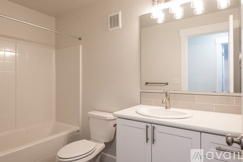 A white bathroom with a toilet, sink, and bathtub.