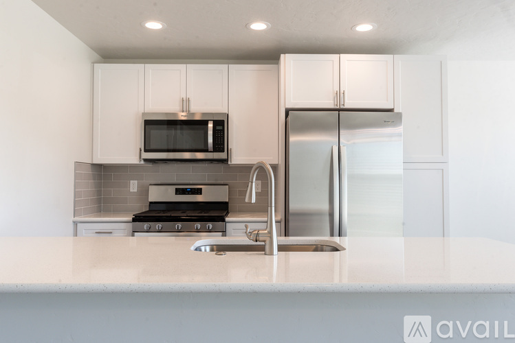 A modern kitchen with a stainless steel refrigerator and microwave above the counter.