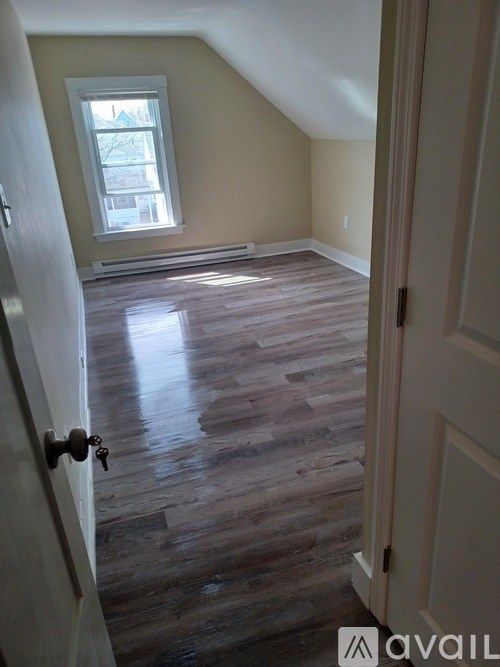 A room with wooden flooring and a window.