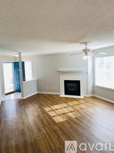 A room with a ceiling fan and wood flooring.