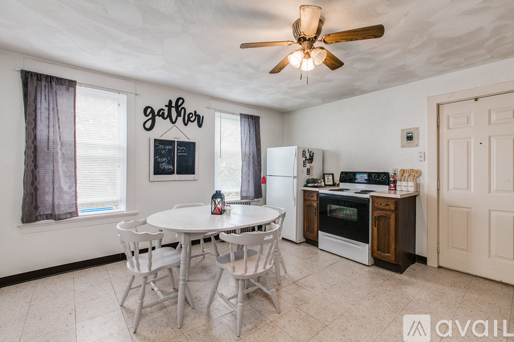 A kitchen with a table and chairs and a fridge.