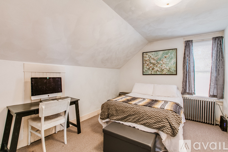 A bedroom with a bed, desk, and chair.