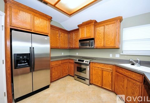 A kitchen with wooden cabinets and a stainless steel refrigerator.
