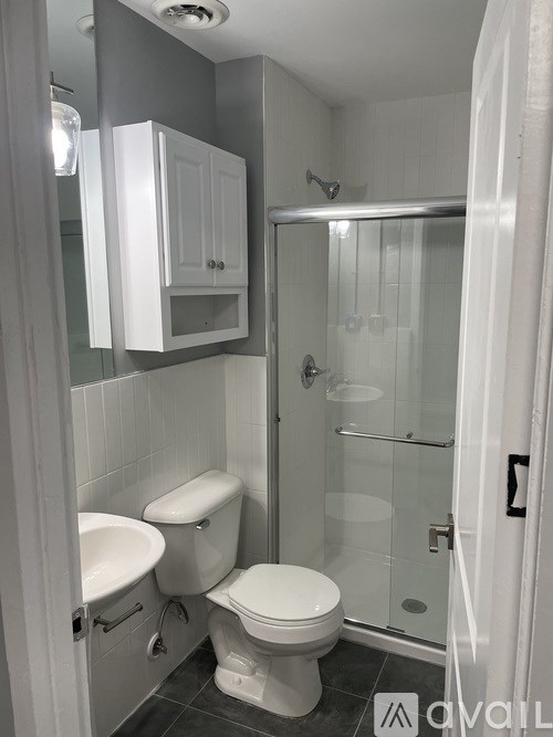 A bathroom with a toilet, sink, and shower.