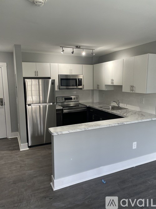 A kitchen with a white counter and stainless steel appliances.