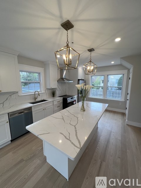 A kitchen with a marble countertop and a large island.
