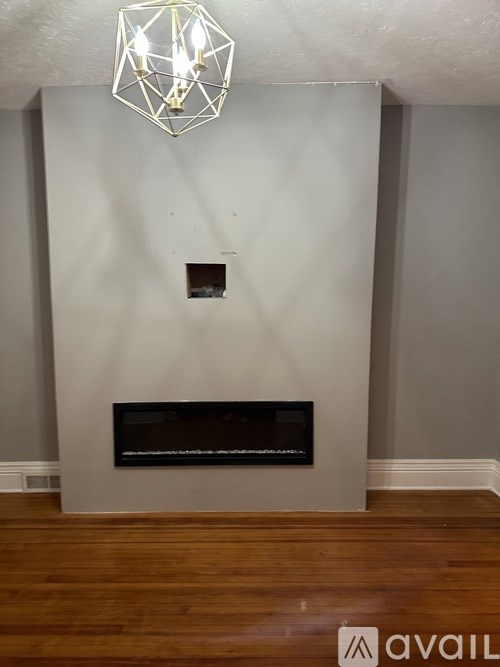 A modern fireplace with a black grate and a wooden mantle.