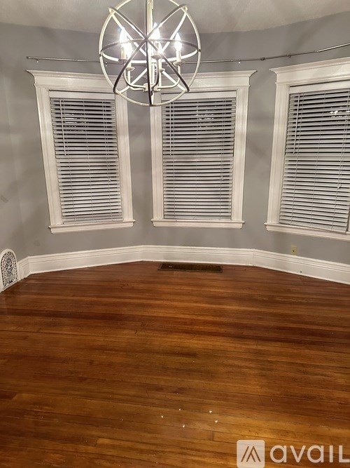 A room with wooden floors and a chandelier.
