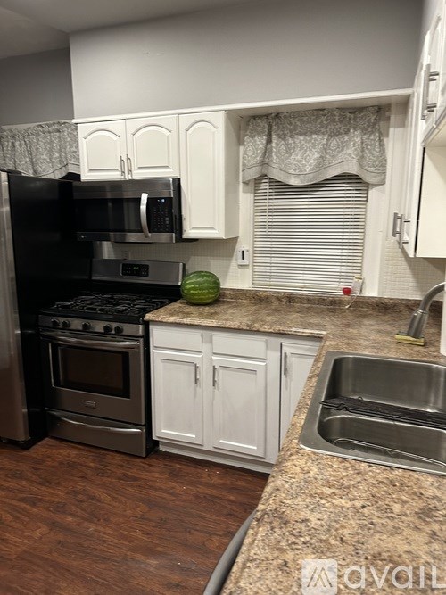 A kitchen with a black fridge, stove, and oven.