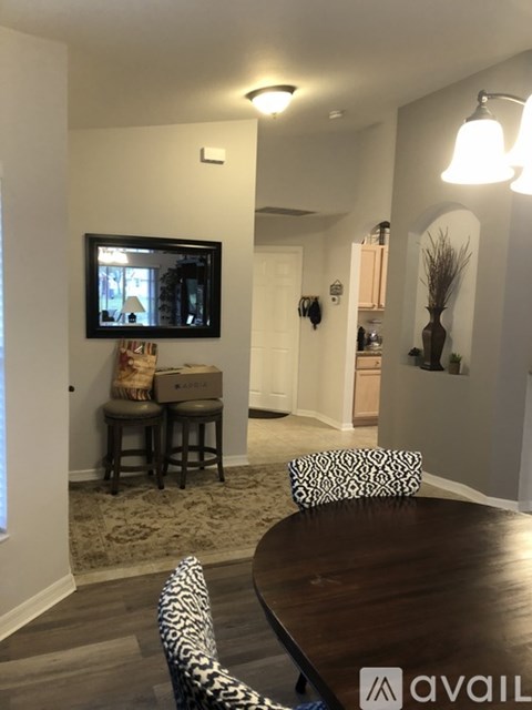 A living room with a brown table and a television on the wall.