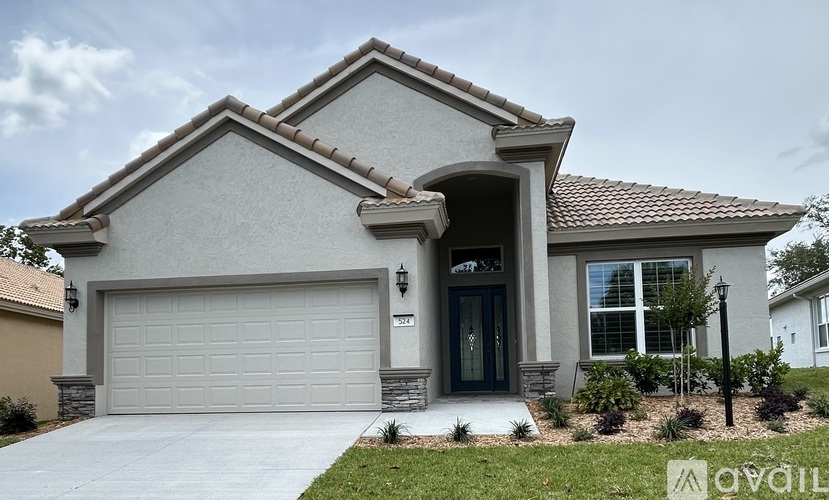 A house with a garage door and a driveway.