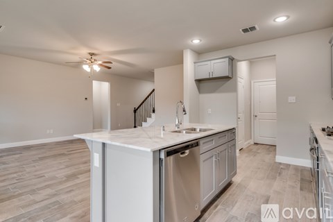 A kitchen with a stainless steel dishwasher and a white countertop.