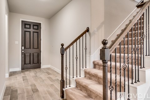 A staircase with a metal railing and a brown door.