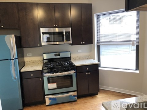 A kitchen with a blue fridge and a black stove top oven.