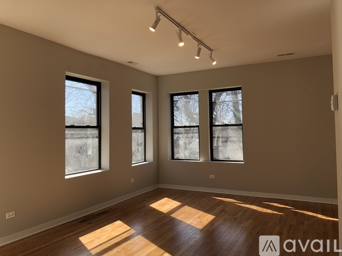 Three windows in a room with wooden floors and white walls.