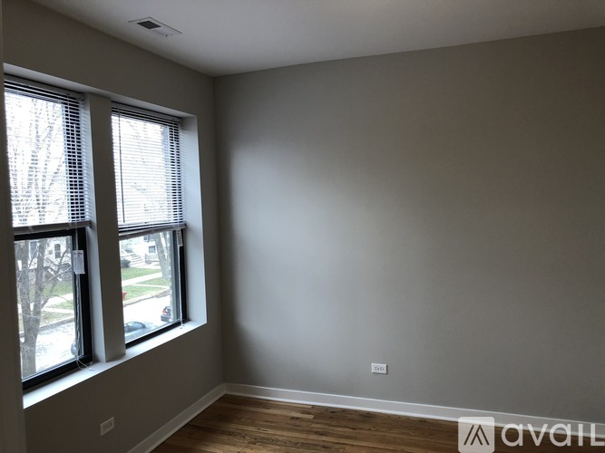 A room with a window and wooden flooring.