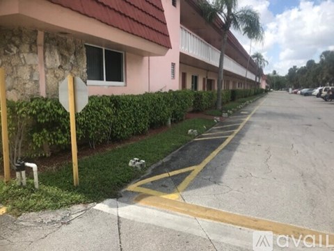 A street with a stop sign and a building with a red roof.