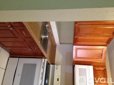 A kitchen with wooden cabinets and a stainless steel range hood.