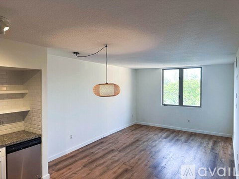 A living room with a grey couch and a flat screen TV mounted on the wall.