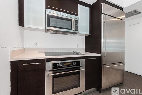 A modern kitchen with a stainless steel refrigerator and oven.