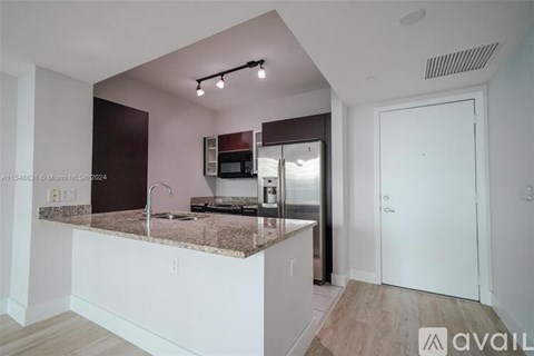 A kitchen with a granite countertop and a sink.